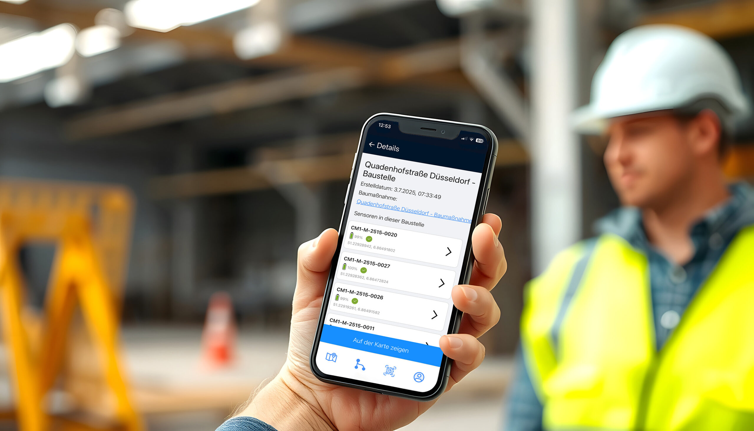 App auf Smartphone zeigt Baustellendetails, Person im Hintergrund.