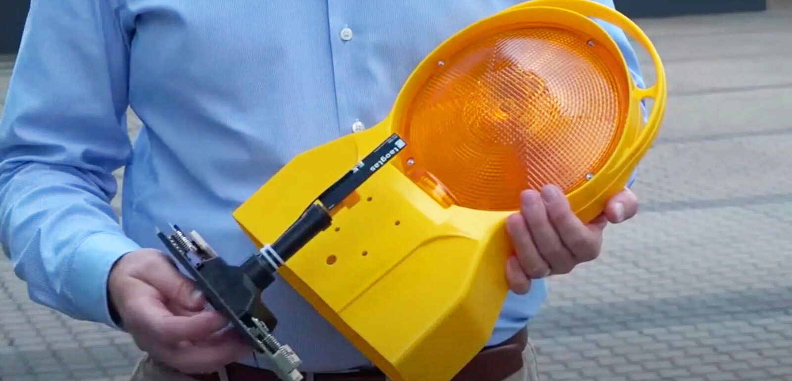 Person hält eine Warnleuchte mit eingebautem Sensor in der Hand.