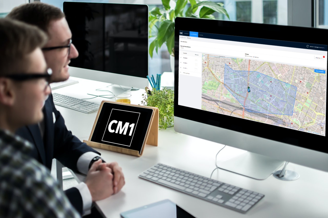 Zwei Männer sehen sich eine digitale Baustellenkarte auf einem Monitor an.